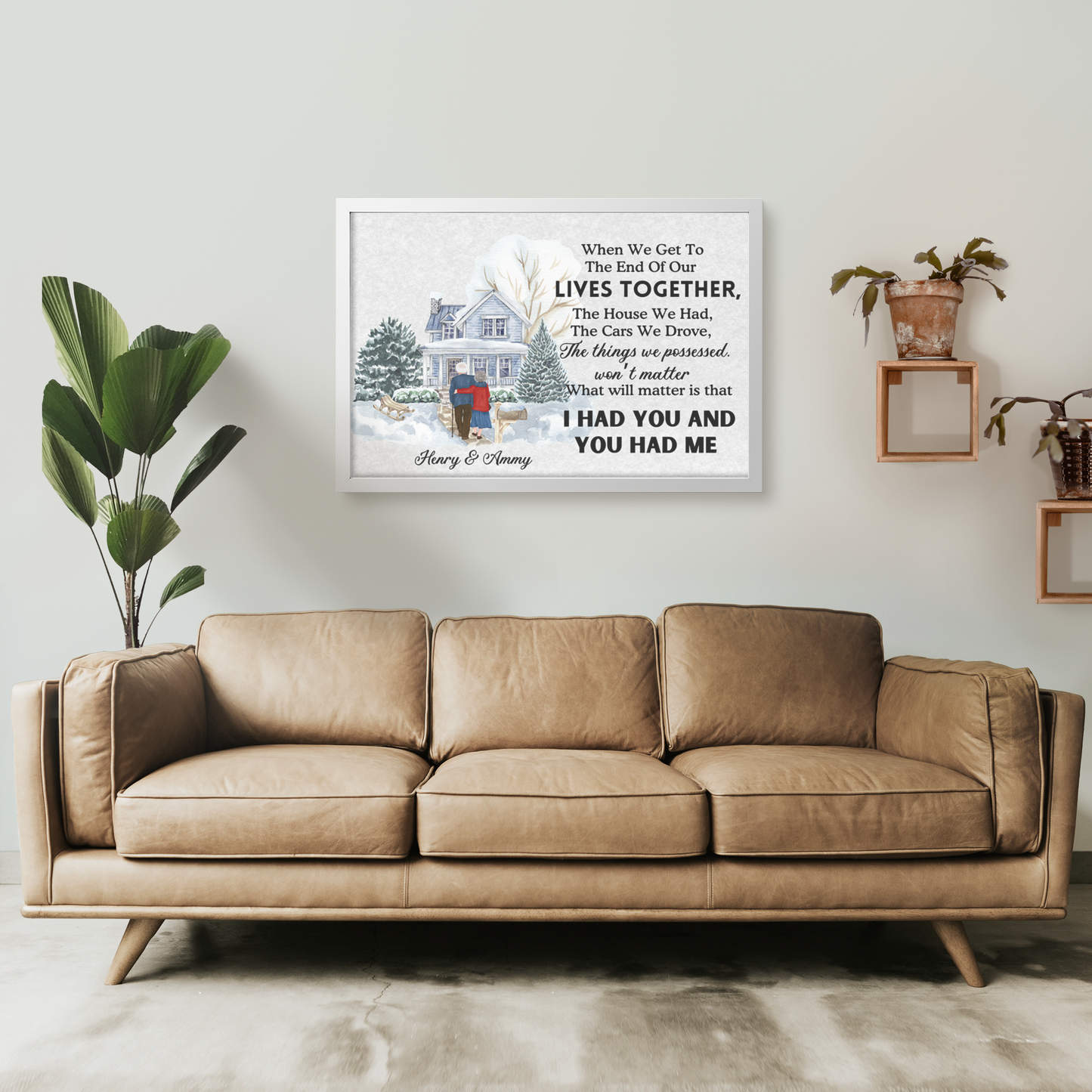 Personalized wall art with a winter cabin scene and sentimental quote in a white frame above a tan leather sofa.