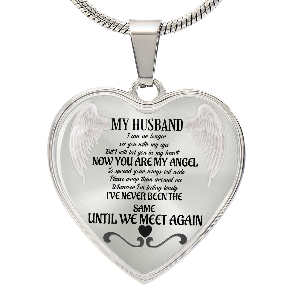 Silver heart-shaped necklace pendant with angel wings and engraved "My Husband" memorial poem in black script.