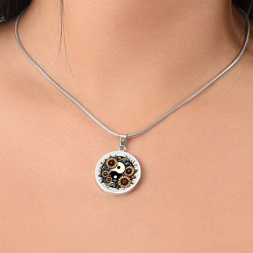Silver necklace with round pendant featuring a black and gold sunflower yin yang design.