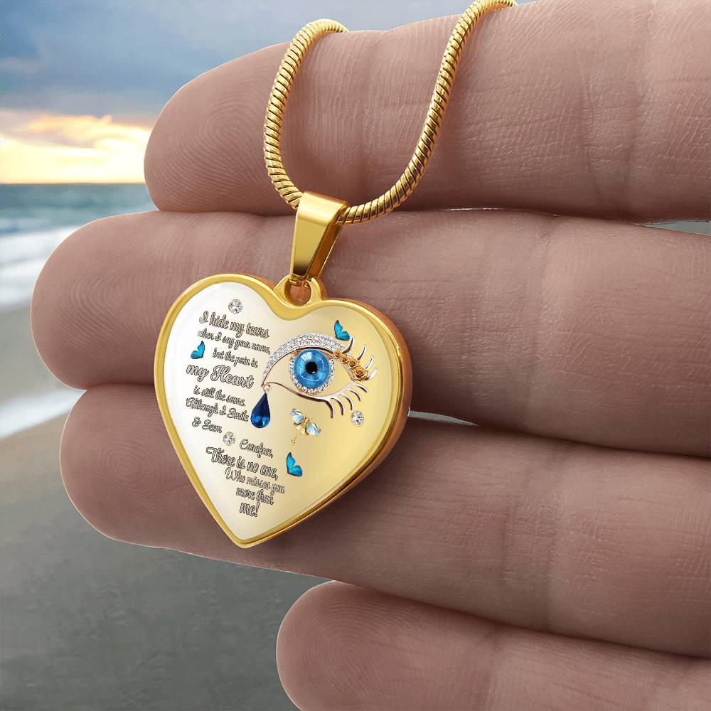 Gold heart-shaped pendant necklace with blue eye design and engraved poetic text.