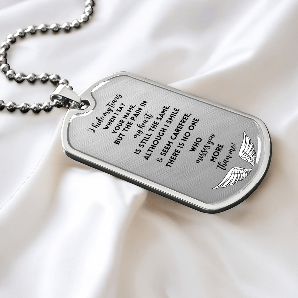 Silver military chain tag necklace with engraved sentimental poem and wing design on satin background.