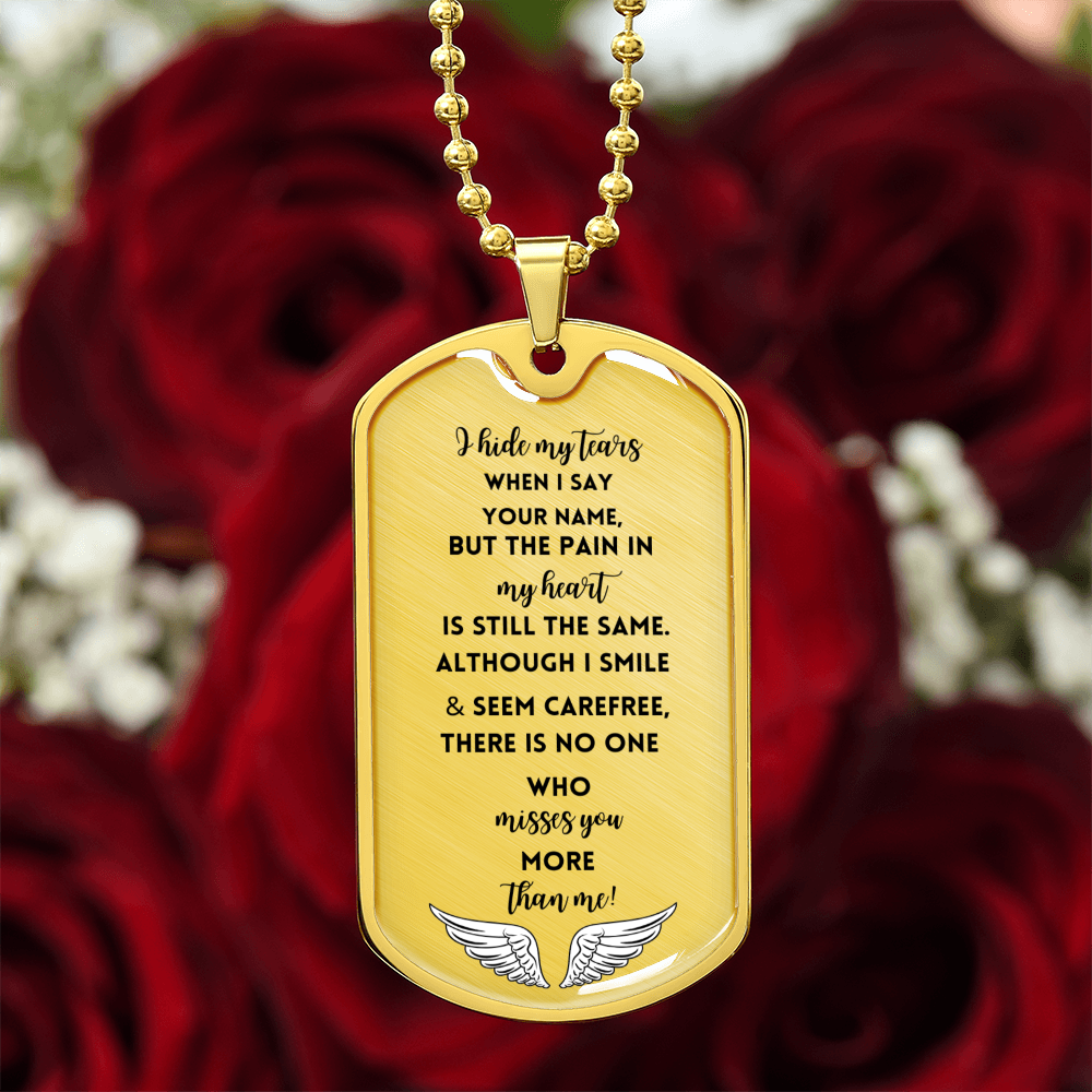 Gold military dog tag necklace with engraved sentimental memorial poem and angel wings, set against red roses background.