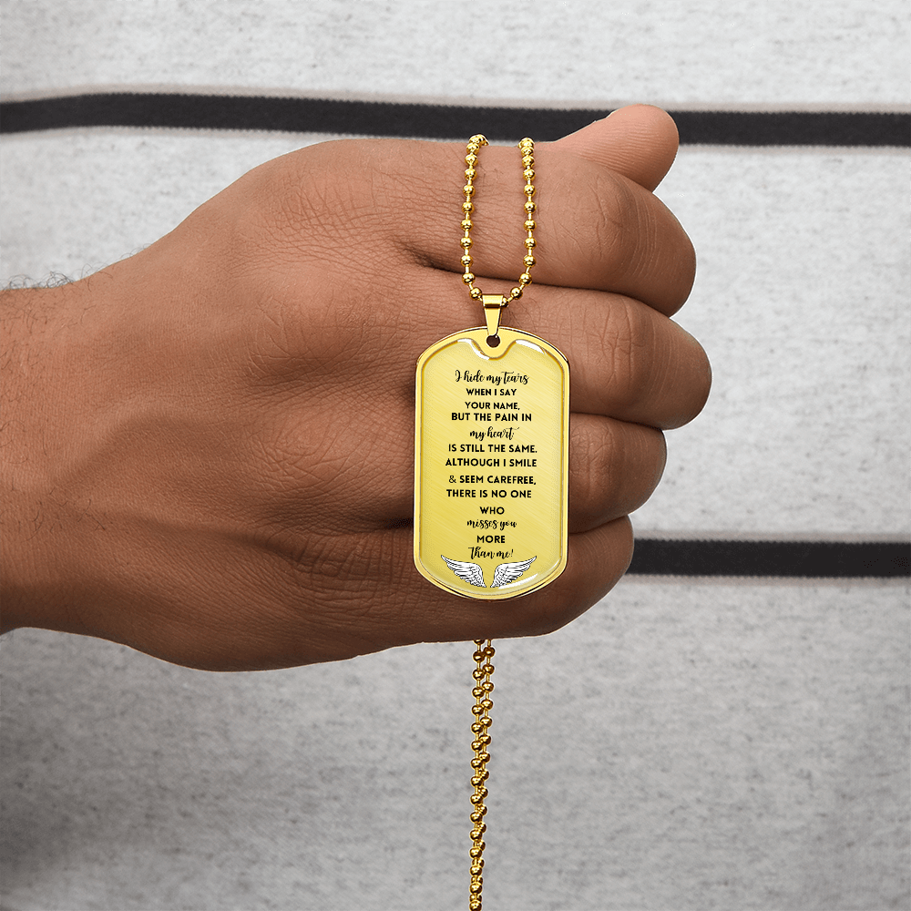 Gold memorial dog tag necklace with engraved sympathy poem and dove design, held in hand.