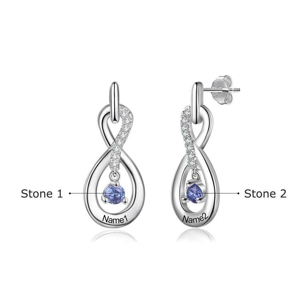 Silver infinity-shaped earrings with clear crystals and a blue birthstone charm engraved with "Name".