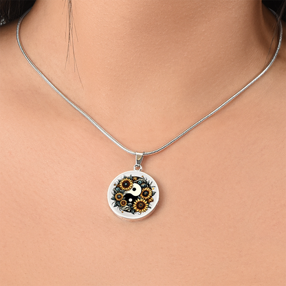 Silver necklace with round pendant featuring a black and gold sunflower yin yang design.