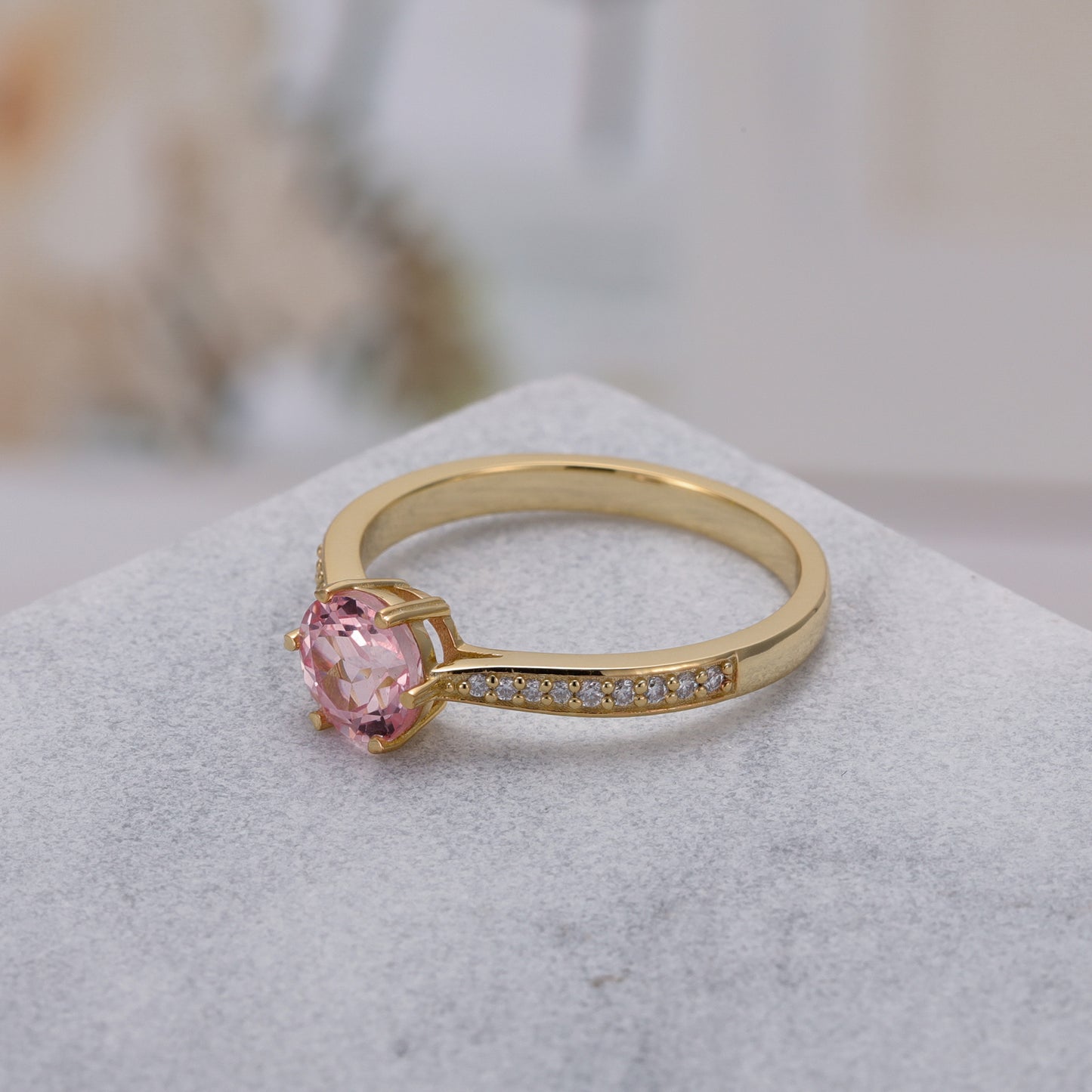 925 Sterling Silver Lab Pink Sapphire Ring with round pink sapphire set in gold-plated band with small accent stones.