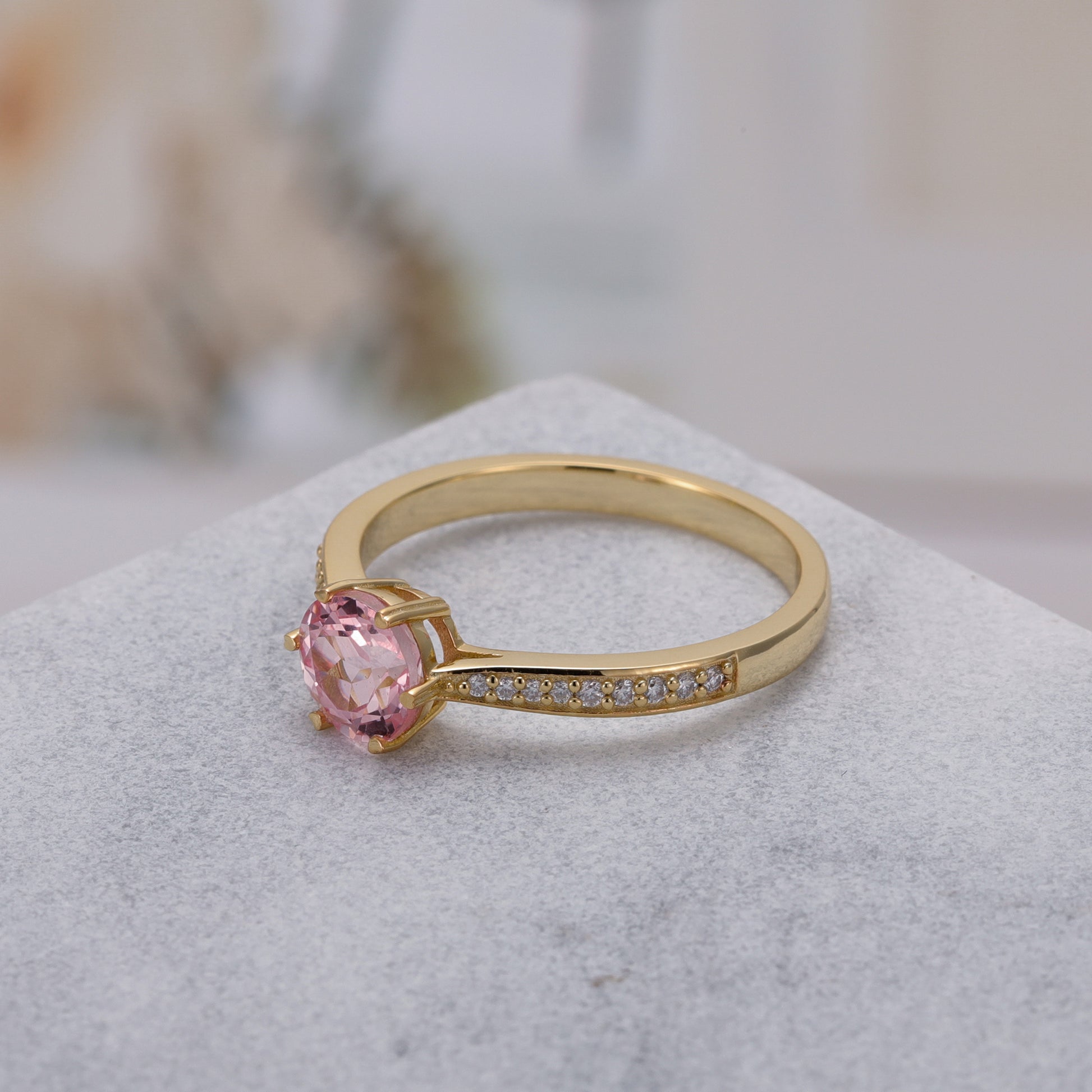 925 Sterling Silver Lab Pink Sapphire Ring with round pink sapphire set in gold-plated band with small accent stones.