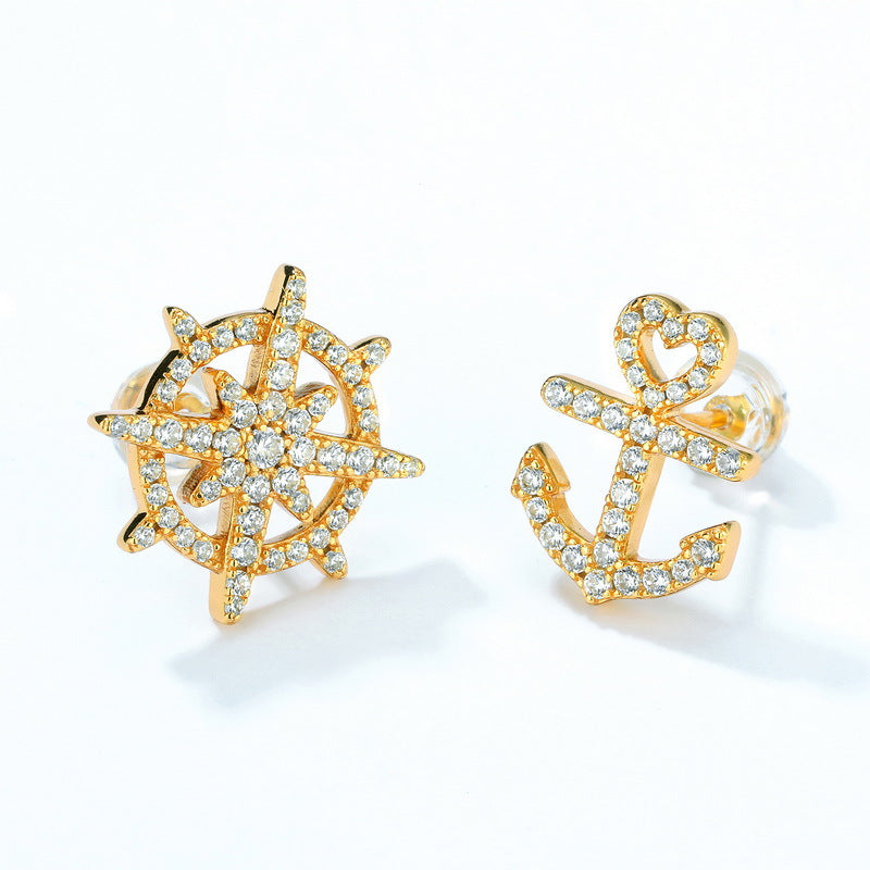 Gold-plated sterling silver earrings featuring nautical-inspired designs: a sparkling ship's wheel and anchor studded with small crystals, showcasing elegant maritime motifs against a white background