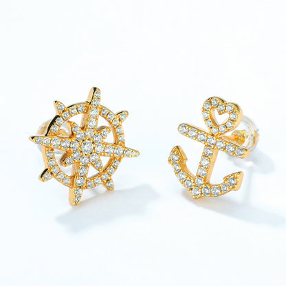 Gold-plated sterling silver earrings featuring nautical-inspired designs: a sparkling ship's wheel and anchor studded with small crystals, showcasing elegant maritime motifs against a white background